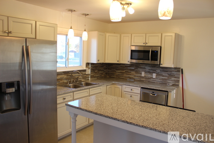 A kitchen with granite countertops and stainless steel appliances.