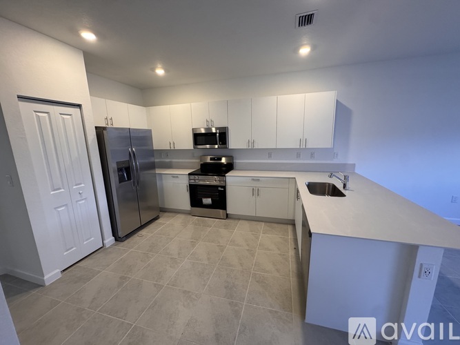 A kitchen with white cabinets and a tiled floor.