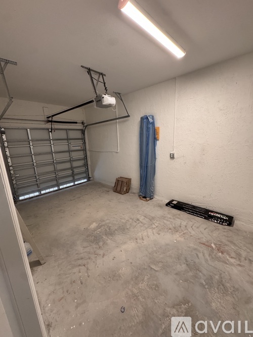 A room with a garage door and a ladder.