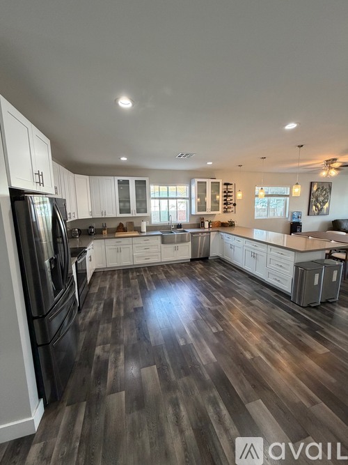 A spacious kitchen with wood flooring and modern appliances.