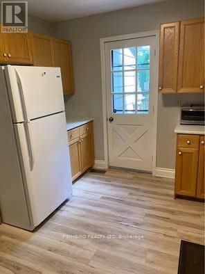 A kitchen with a white fridge and wooden cabinets.