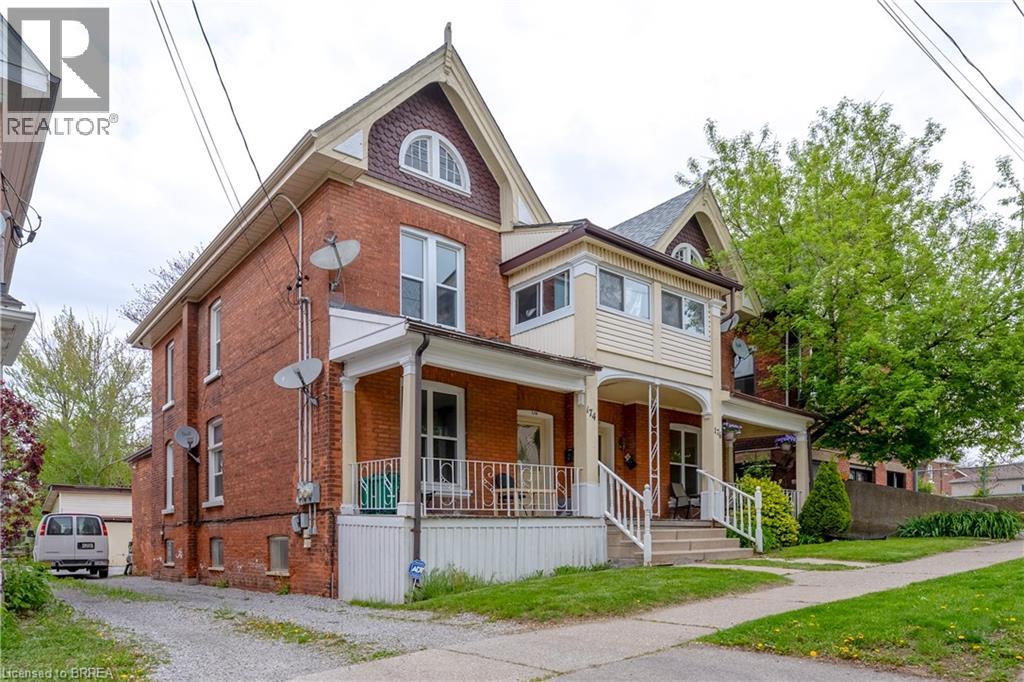 A house with a red brick exterior and a white porch.