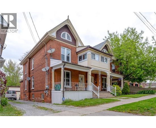 A house with a red brick exterior and a white porch.