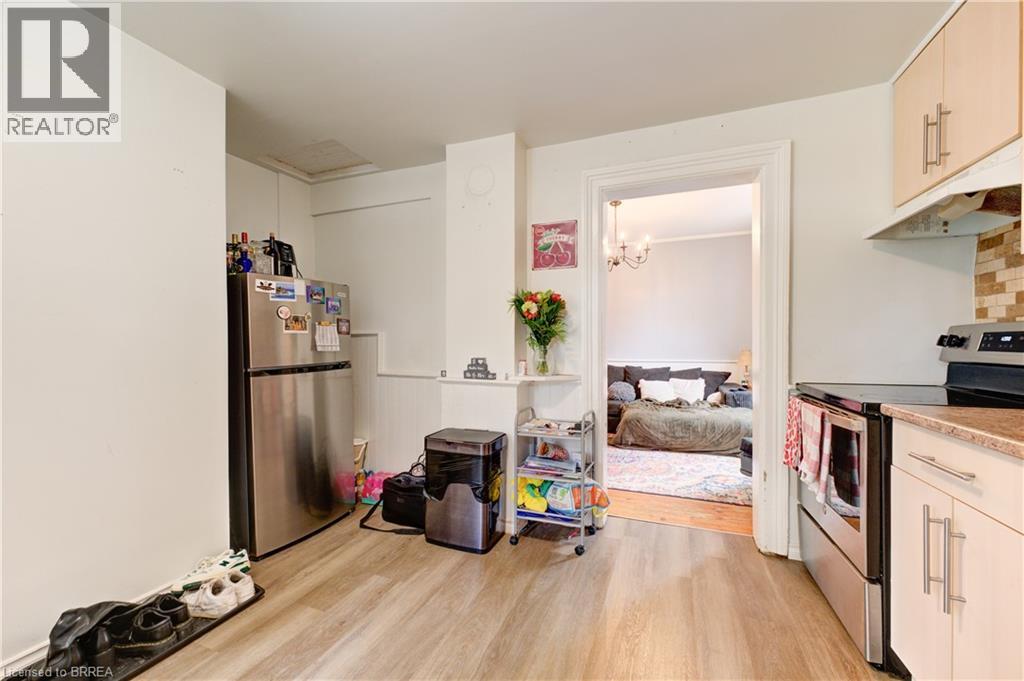 A kitchen with a refrigerator, a dishwasher, and a stove top oven.