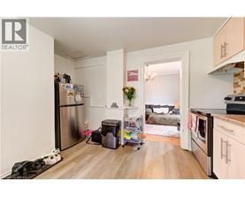 A kitchen with a refrigerator, a dishwasher, and a stove top oven.