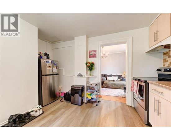 A kitchen with a refrigerator, a dishwasher, and a stove top oven.