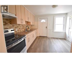 A kitchen with wooden cabinets and a black stove top oven.