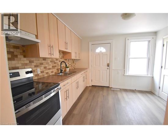 A kitchen with wooden cabinets and a black stove top oven.