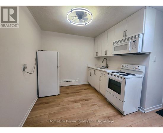 A kitchen with white appliances and cabinets.