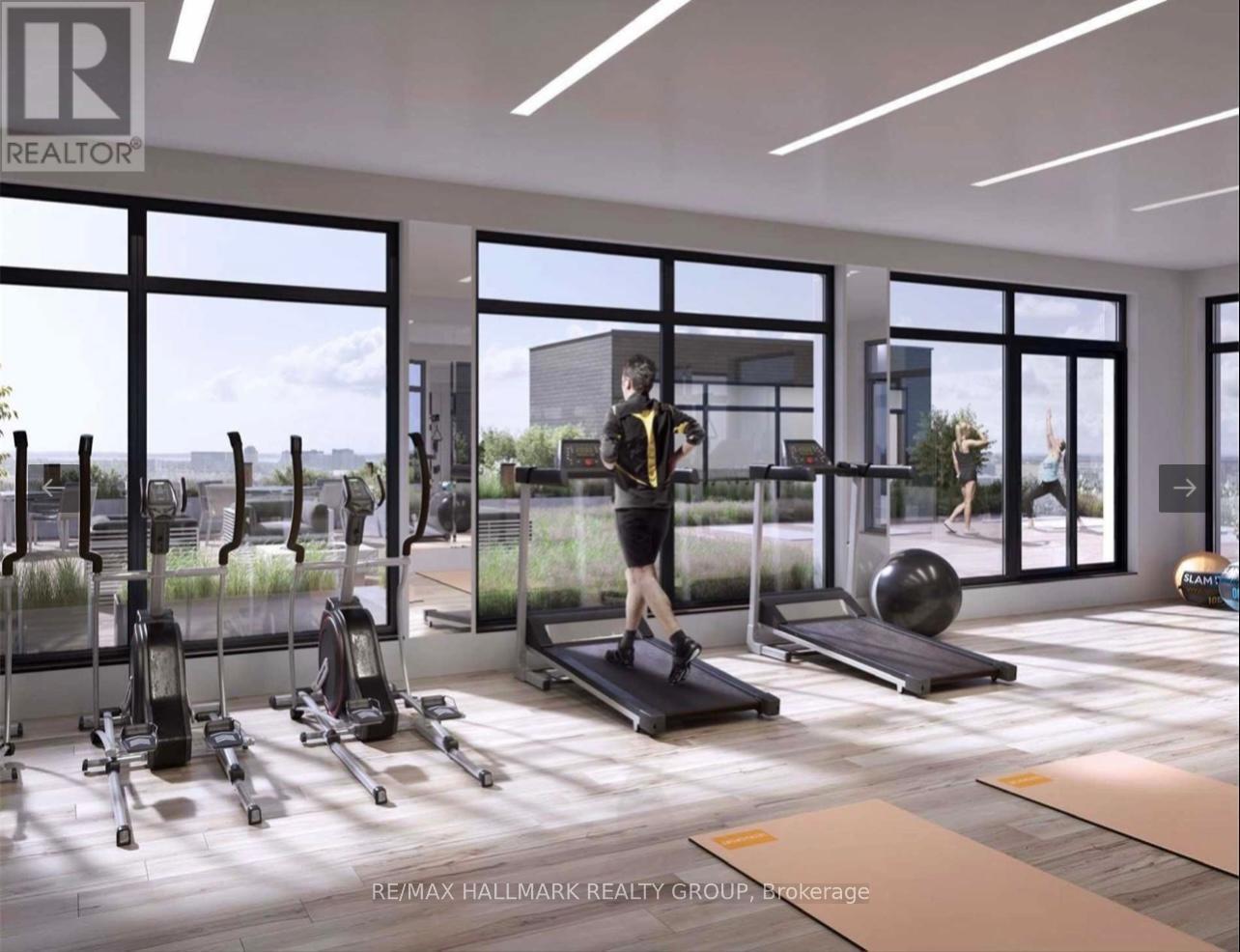 A woman is working out on a treadmill in a spacious gym with various exercise equipment.