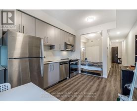 A kitchen with a refrigerator, microwave, oven and sink.