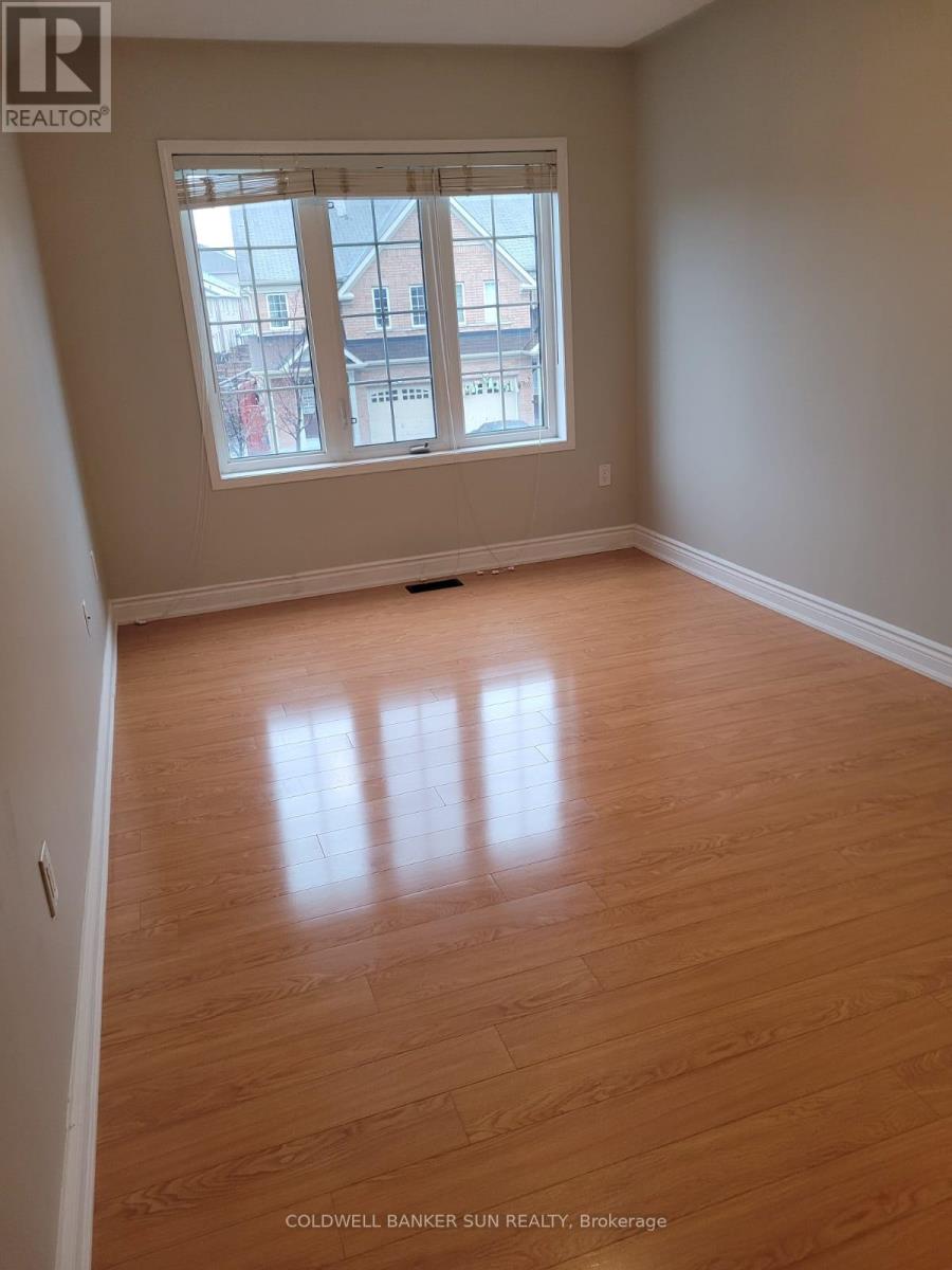 A room with wooden flooring and a large window.