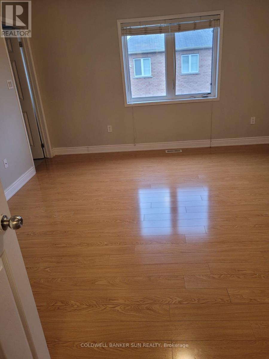 A room with a window and wooden flooring.