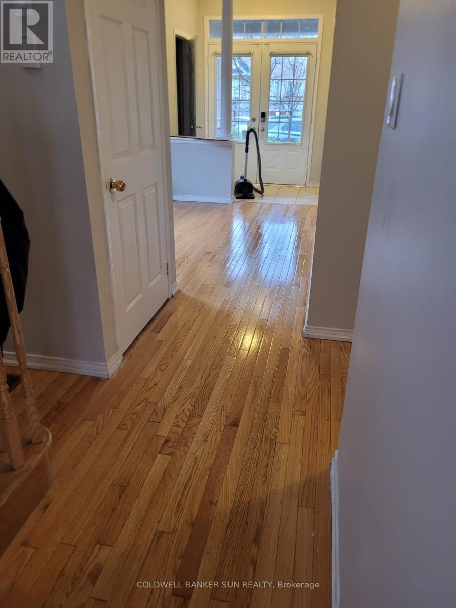 A hallway with a wooden floor and a door on the left.