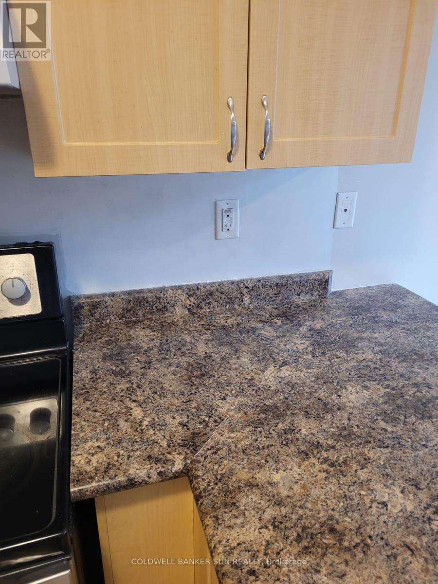 A kitchen counter with a granite top and a black dishwasher.