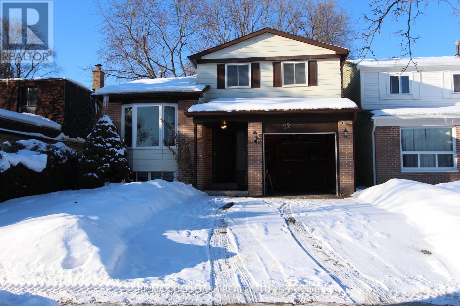 A house with a snow-covered driveway in front.
