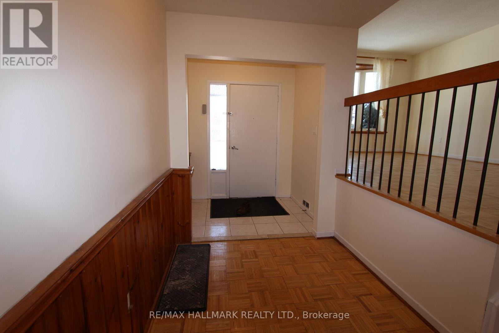 A hallway with a door and a mat on the floor.