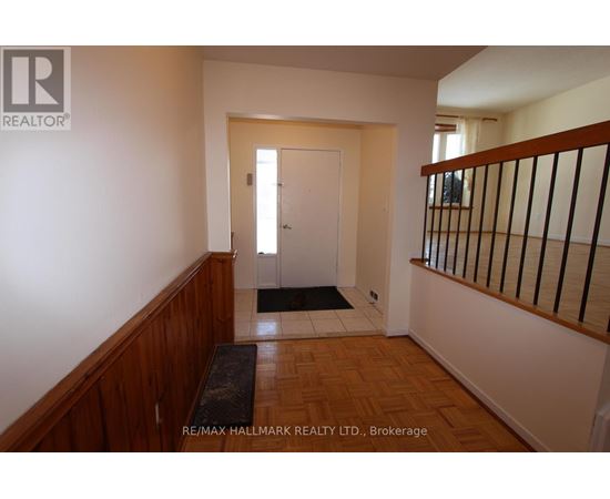 A hallway with a door and a mat on the floor.