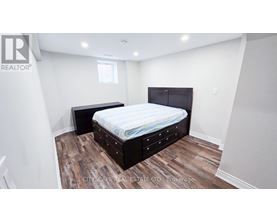 A bedroom with a bed and a wooden floor.