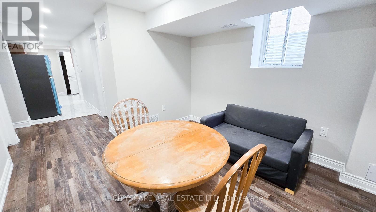 A dining room with a wooden table and chairs.