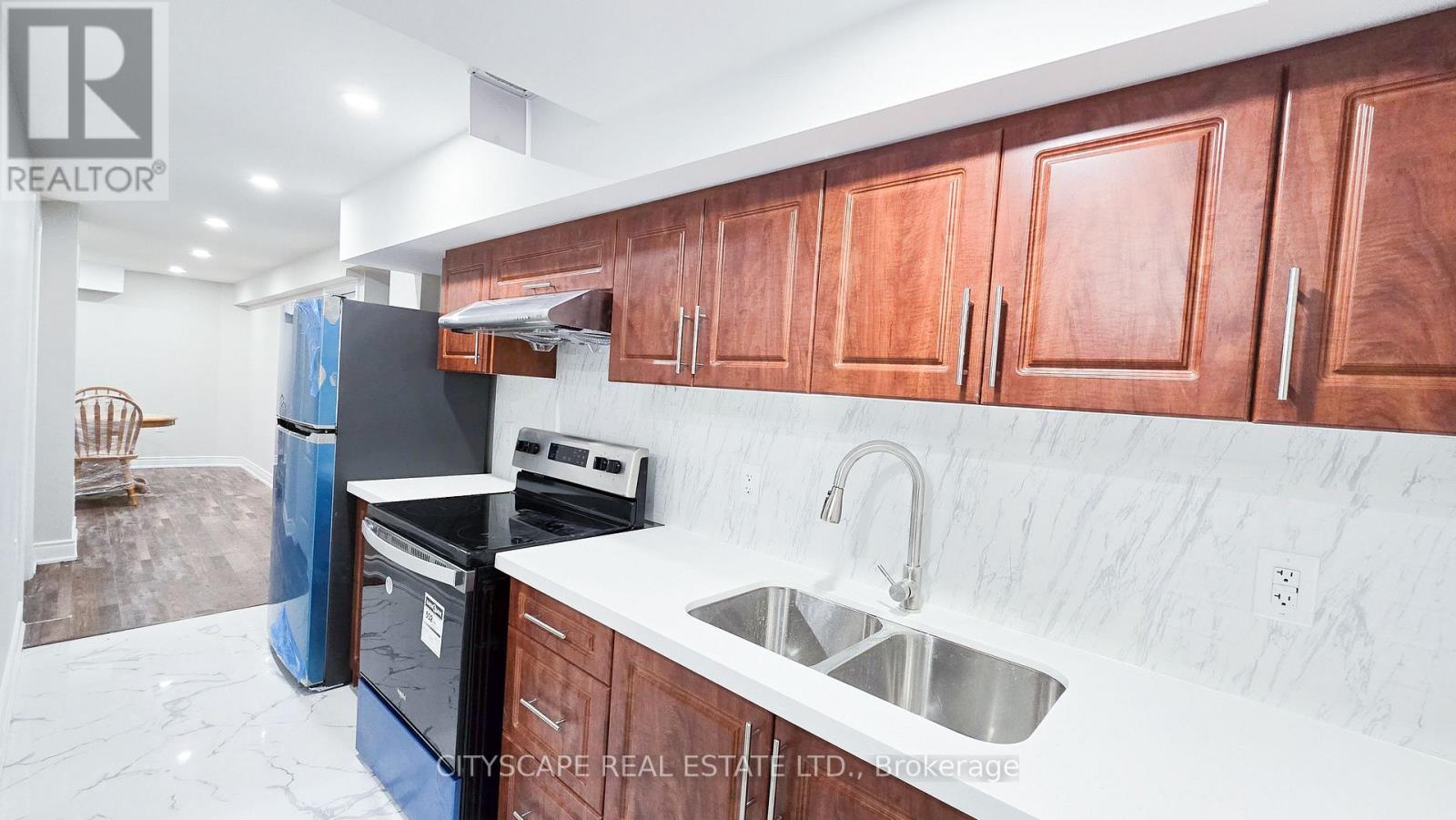 A kitchen with wooden cabinets and a marble countertop.