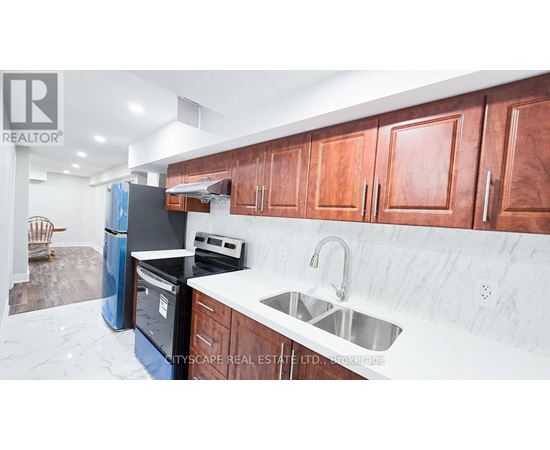 A kitchen with wooden cabinets and a marble countertop.