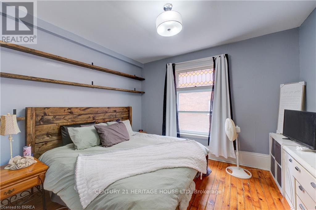 A bedroom with a bed, nightstand, and a window with curtains.