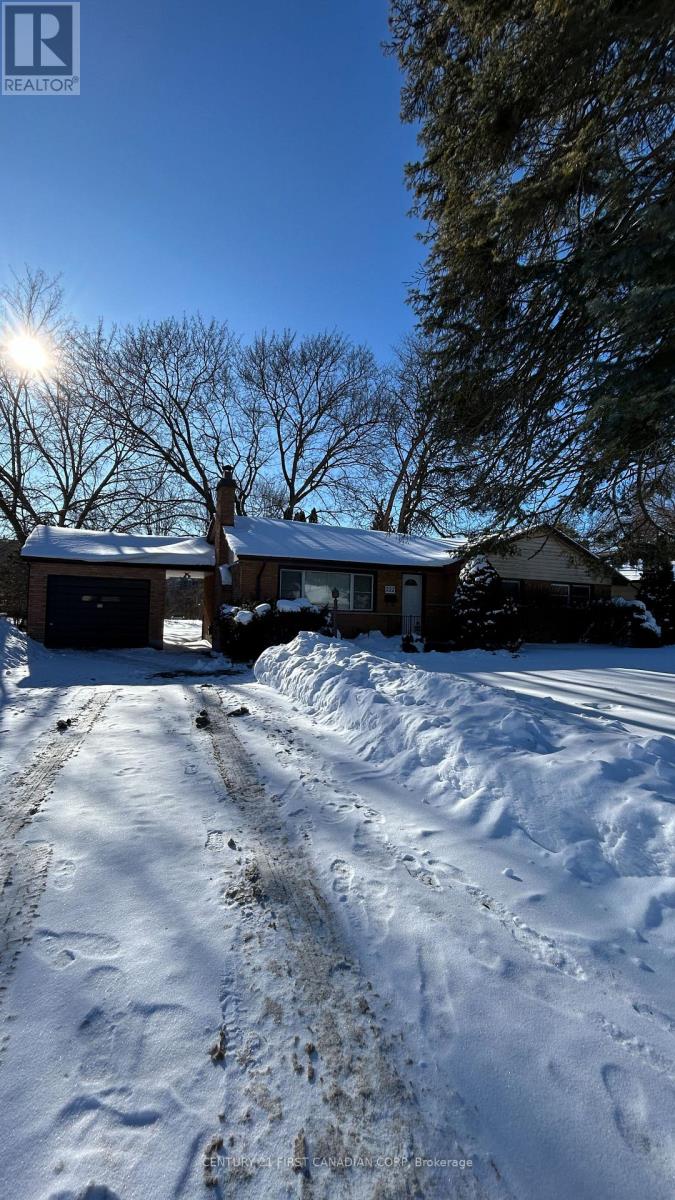 A house with a snow-covered driveway in front of it.
