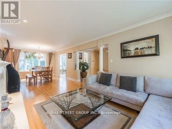 A spacious living room with a white sofa and a glass coffee table.