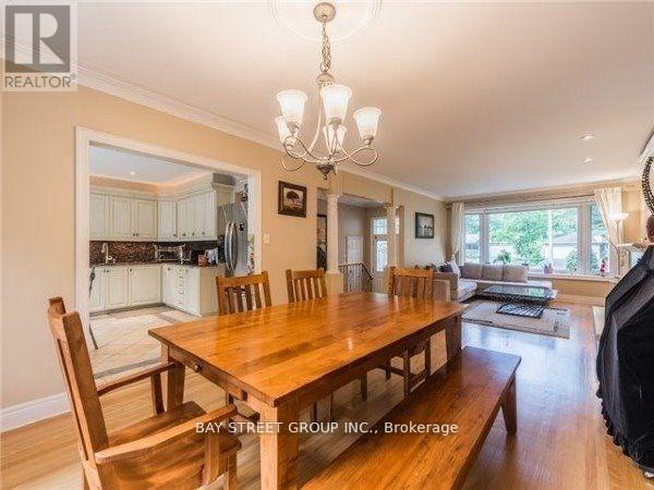 A dining room with a wooden table and chairs.