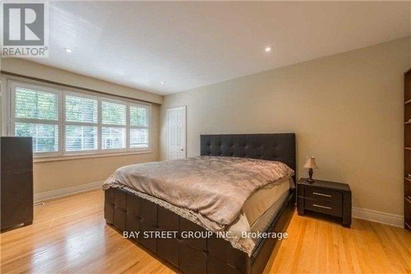 A bedroom with a large bed and a nightstand with a lamp.