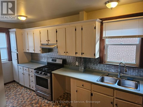 A kitchen with wooden cabinets and a tiled floor.