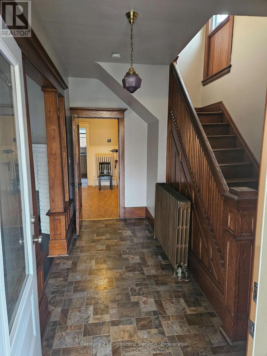 A hallway with a staircase and a chandelier.