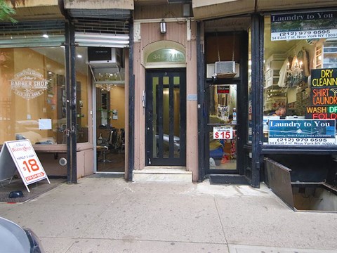the front door of a store with a sale sign on the sidewalk