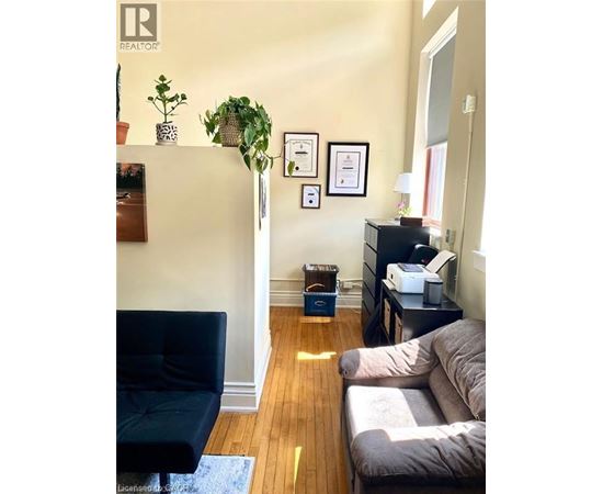 A living room with a black chair and a grey couch.