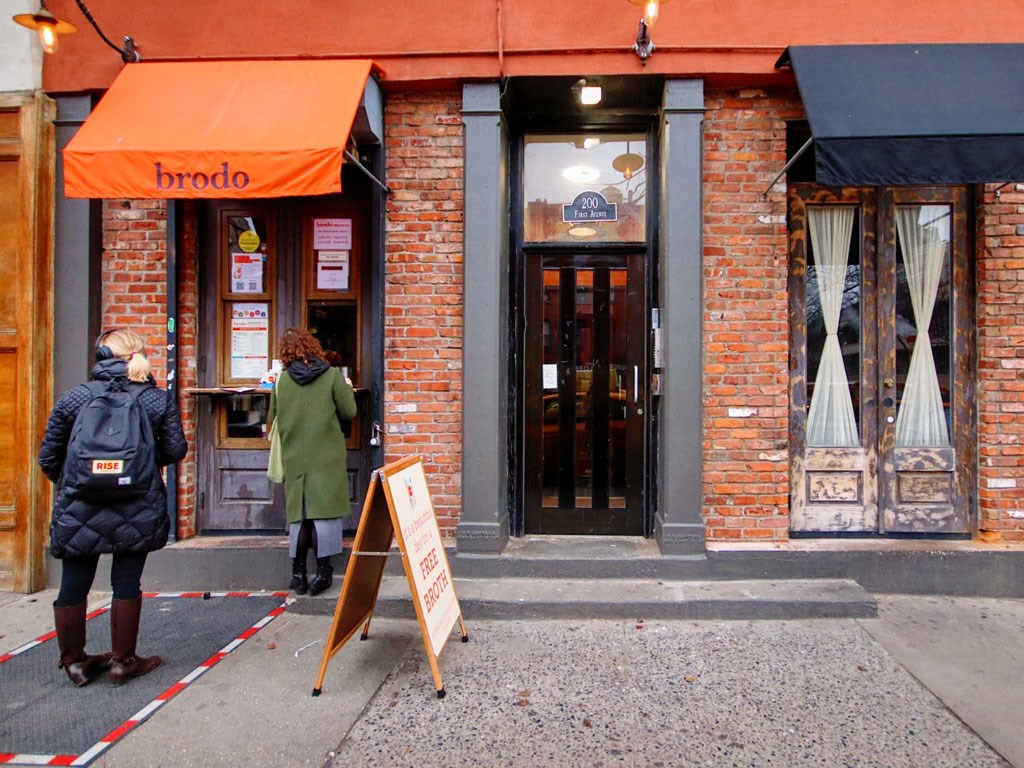 people standing outside of a brick building with a door
