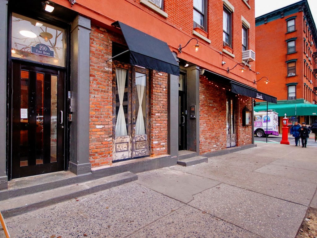 a city street with a red brick building and a sidewalk