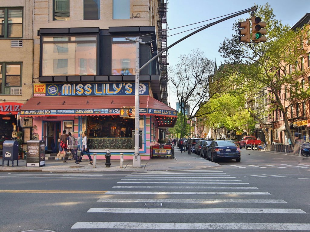 a busy city street with a crosswalk in front of a restaurant