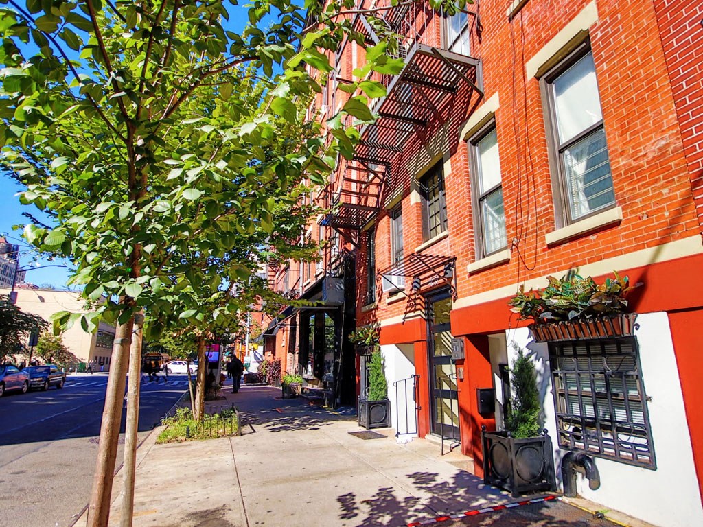 a city street with red brick buildings and trees