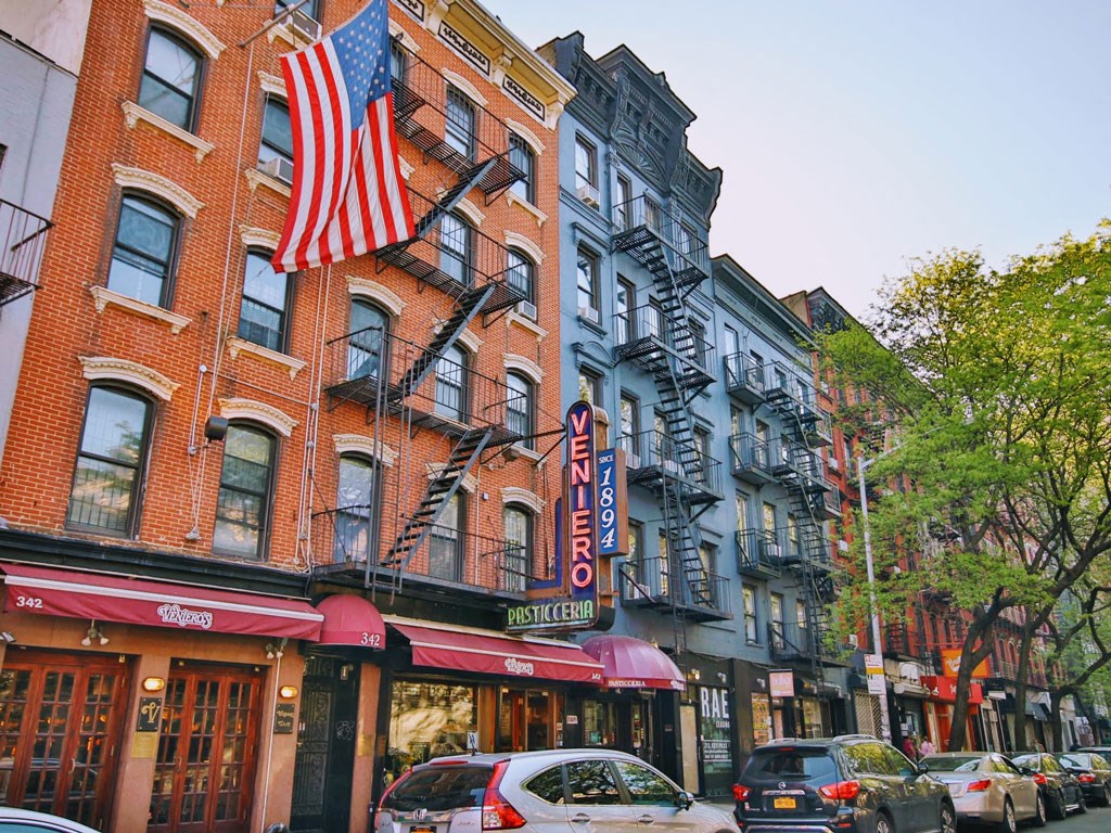 a city street with cars and buildings and an flag