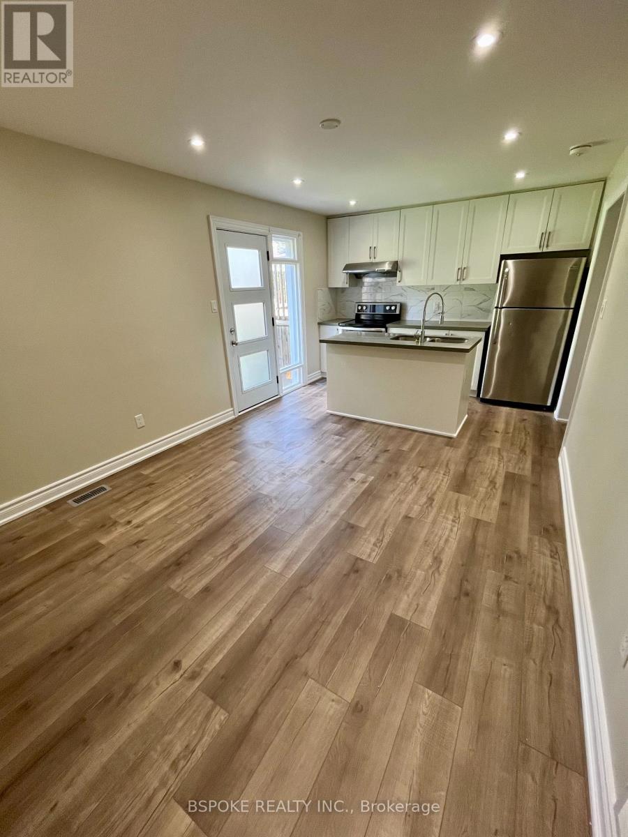 A kitchen with wood flooring and white walls.
