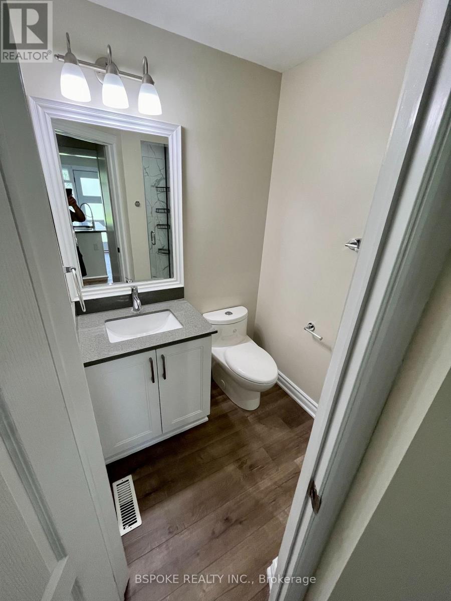 A small bathroom with a toilet, sink, and mirror.