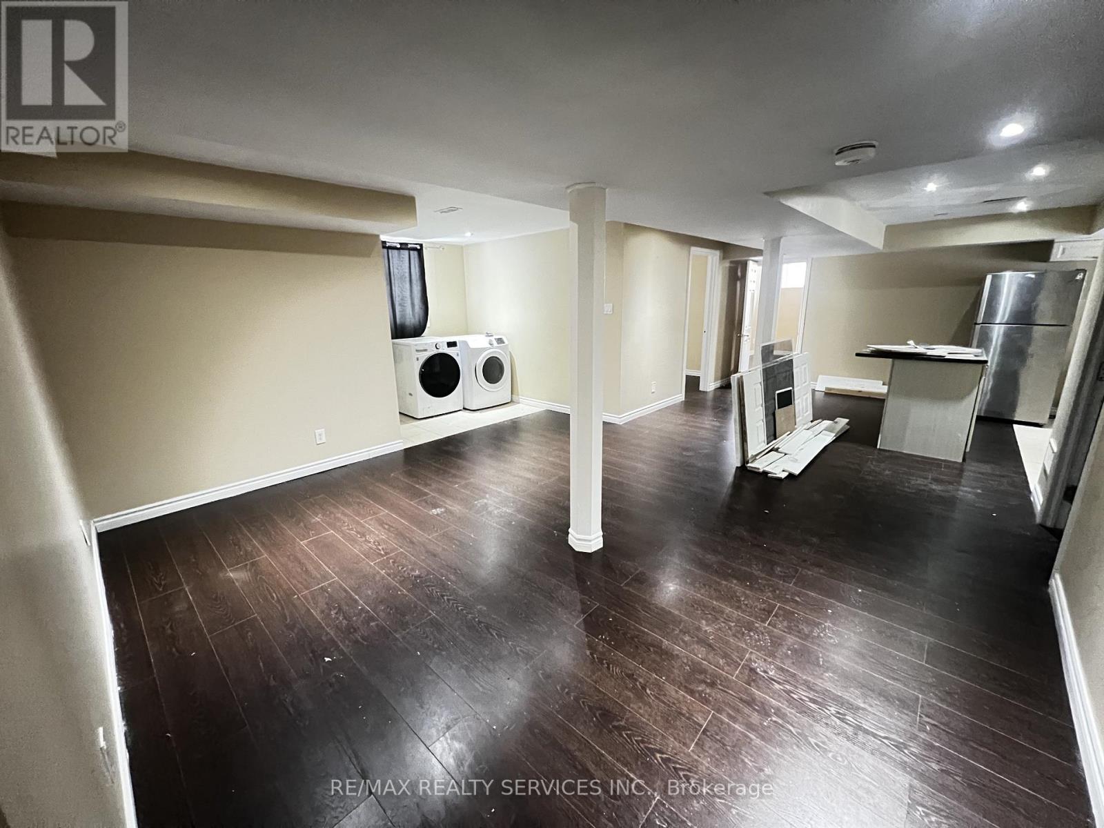 A spacious room with wooden floors and a white ceiling.