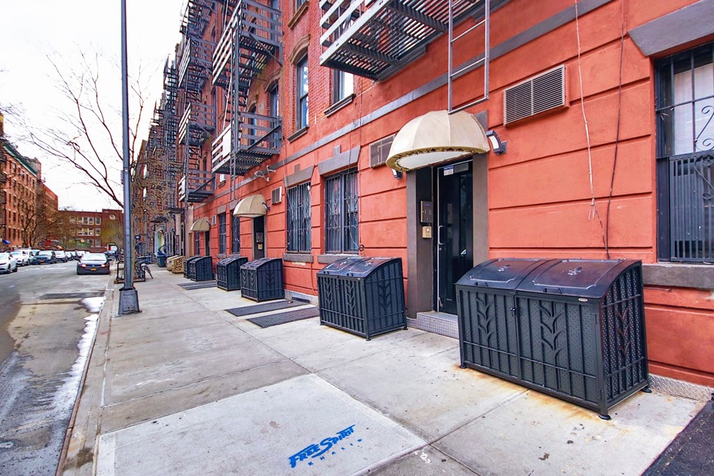 an empty sidewalk in front of a red building