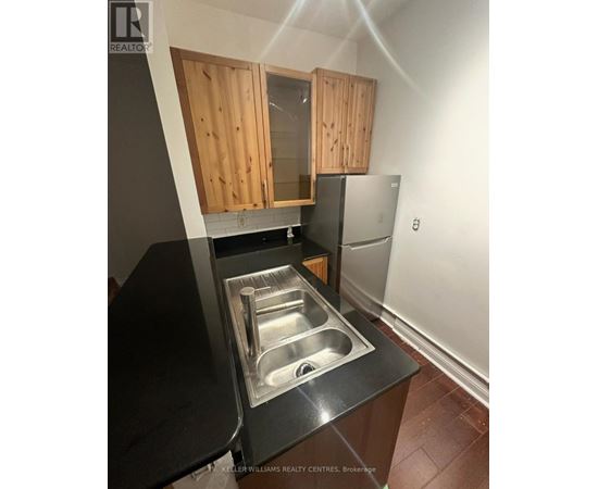A kitchen with a sink and wooden cabinets.