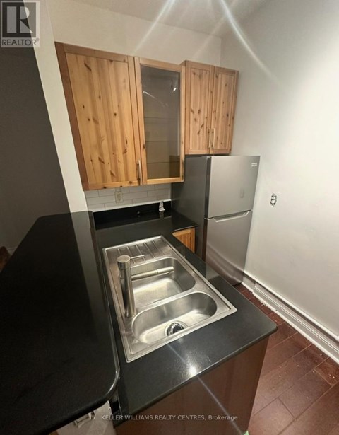 A kitchen with a sink and wooden cabinets.