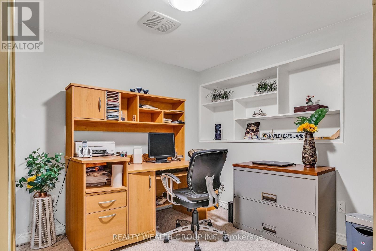 A well-organized office space with a wooden desk, chair, and shelving unit.