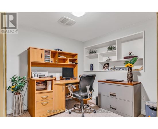 A well-organized office space with a wooden desk, chair, and shelving unit.