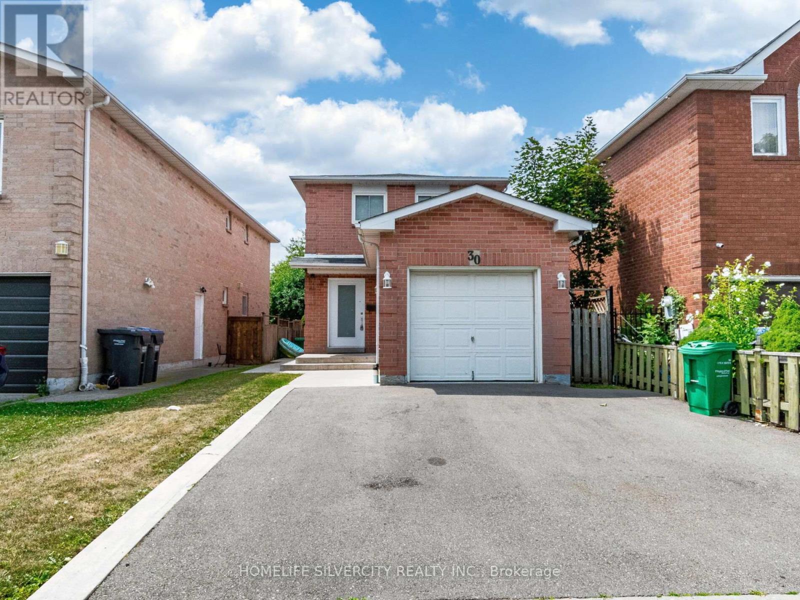 A house with a garage and a driveway in front of it.