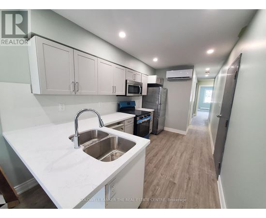 A kitchen with white countertops and stainless steel appliances.